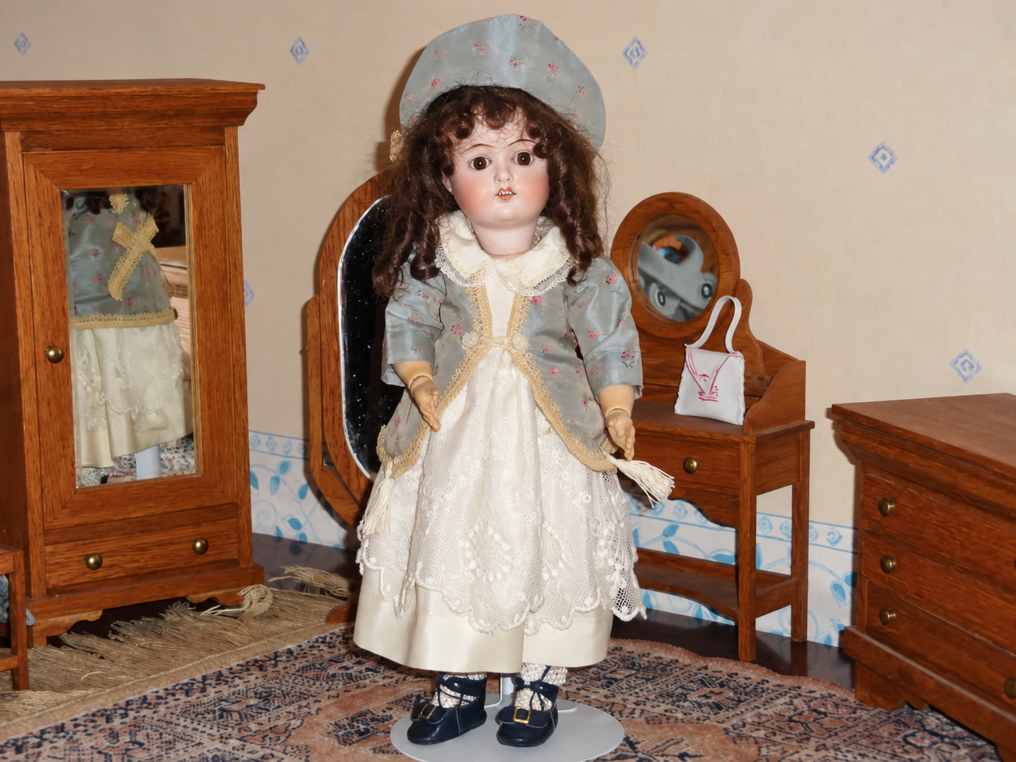 Poupée Goebel — tenue de soie — Vue de face : poupée en tenue complète, présentée dans un décor miniature — vue 1.