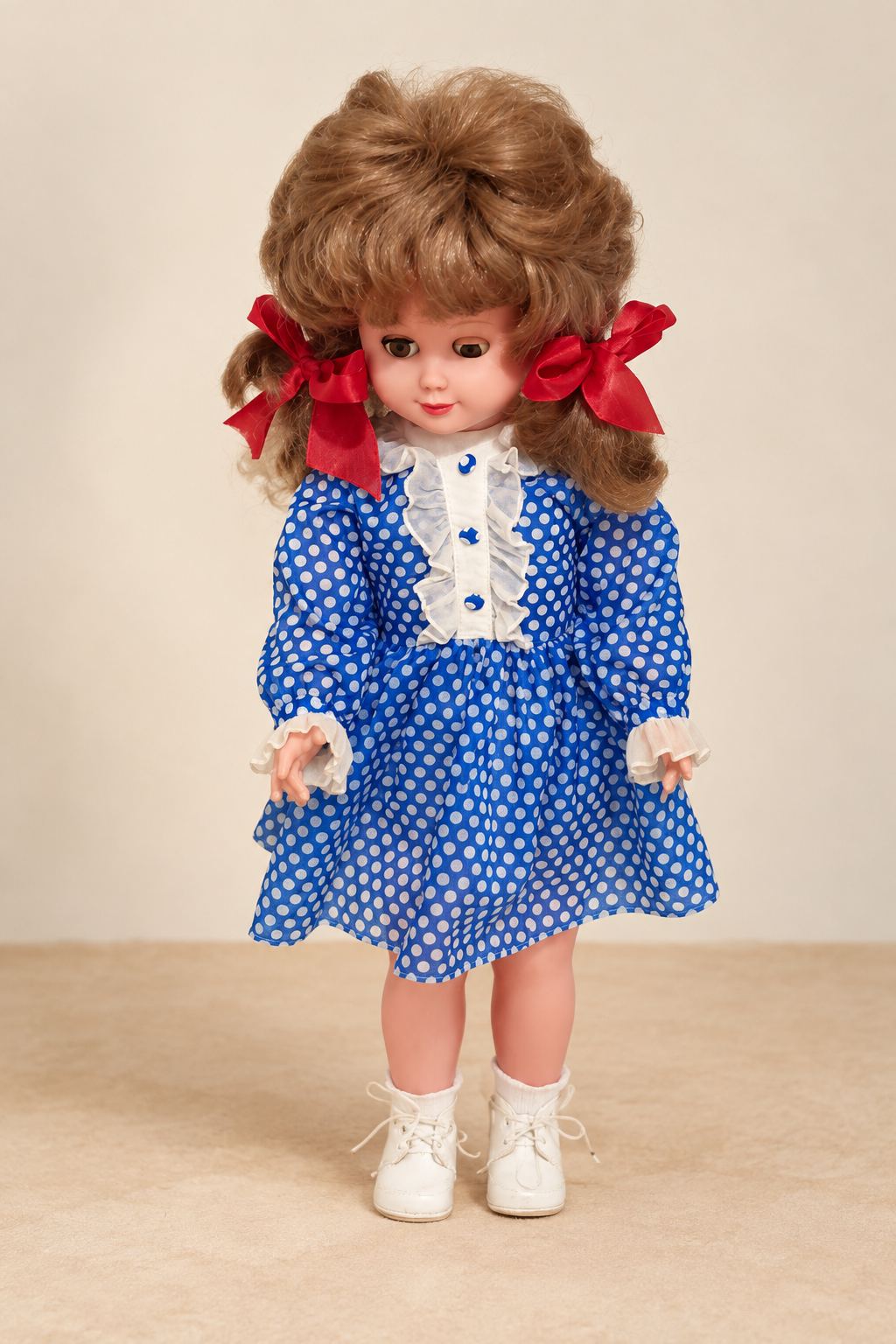 Poupée Unica de 60 cm — la trouvaille de Karin — La poupée Unica présentée par Karin, en robe bleue à pois blancs et rubans rouges — vue 1.